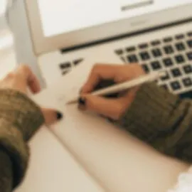 Image représentant une personne qui travaille et écrit dans un cahier pour illustrer l'article : Comment rendre son site WordPress éthique et conforme à la RGPD ?