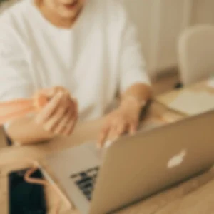 Image représentant 1 personne assise à son bureau, en train de travailler devant un écran d’ordinateur pour illustrer l'article : Site internet écologique : 10 actions pour réduire l’impact carbone de ton site sans nuire à ton activité (voir même la booster)